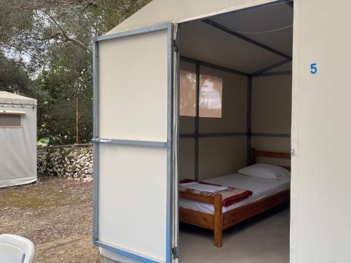 a small bedroom with a bed in a tent at Camping Paleokastritsa in Paleokastritsa