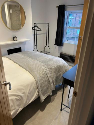 a bedroom with a bed and a mirror and a window at Kings reach eton, great location in Eton