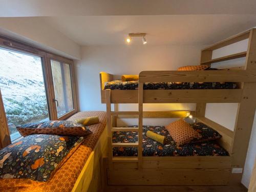 ein Zimmer mit zwei Etagenbetten und einem Fenster in der Unterkunft Chalet de l'Olympe in Les Allues