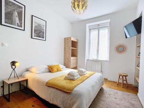 une chambre avec un grand lit avec des serviettes dessus dans l'établissement Studio Loubet, à Cherbourg en Cotentin