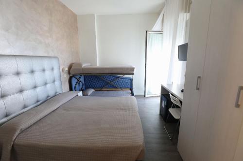 a small bedroom with a bed and a television at Hotel Daniel's FRONTE MARE in Riccione