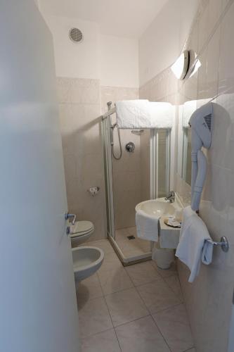 a bathroom with a shower and a toilet and a sink at Hotel Daniel's FRONTE MARE in Riccione