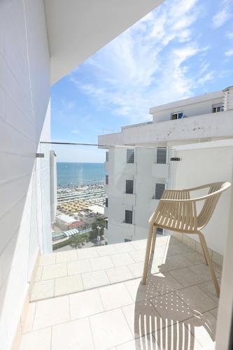 a chair sitting on the balcony of a building at Hotel Daniel's FRONTE MARE in Riccione
