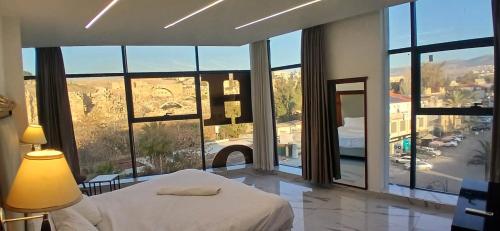 a bedroom with a bed and a large window at Jerash Hotel in Jerash