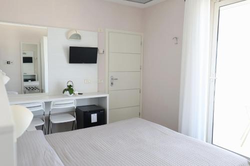a white bedroom with a bed and a desk at Hotel Daniel's FRONTE MARE in Riccione