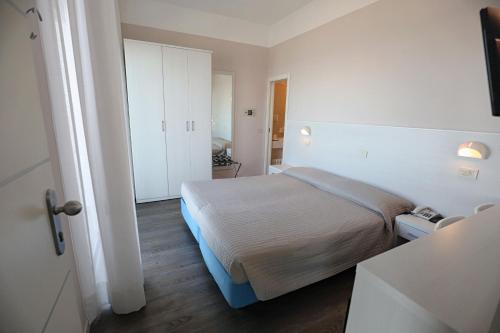 a bedroom with a bed in a white room at Hotel Daniel's FRONTE MARE in Riccione