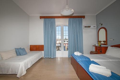 a hotel room with two beds and a window at Anadiomeni Pool & Beach Apartments by "elite" in Zakynthos