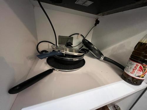 a pot and spoon on a stove next to a bottle at Sukoon by Urban Retreat in New Delhi