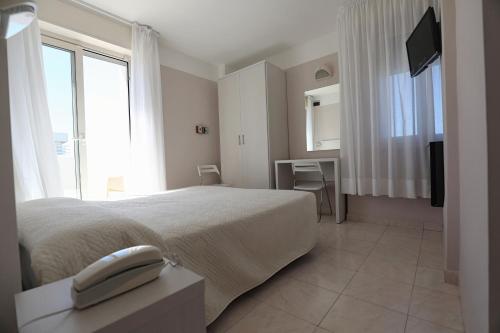 a hotel room with a phone on a bed at Hotel Daniel's FRONTE MARE in Riccione