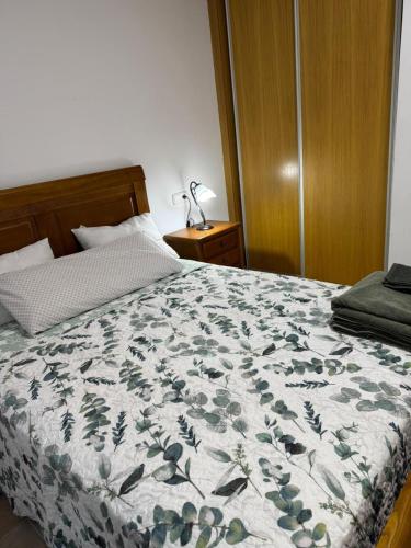 une chambre avec un lit avec une couette fleurie dans l'établissement Apartamento en Bogarra, à Bogarra