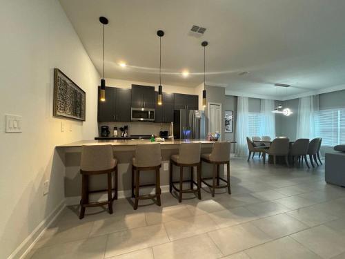 a kitchen and dining room with a bar and chairs at 5BR w/Private Pool | Luxury at Storey Lake in Kissimmee