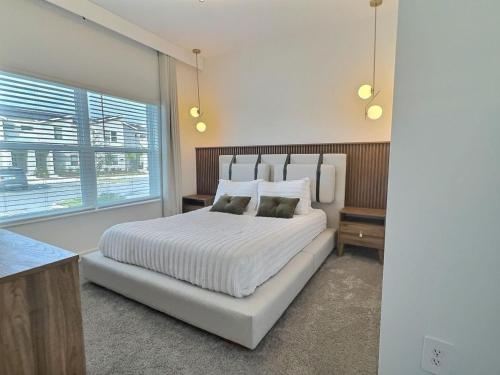 キシミーにある5BR w/Private Pool | Luxury at Storey Lakeの大きな白いベッドと窓のある寝室