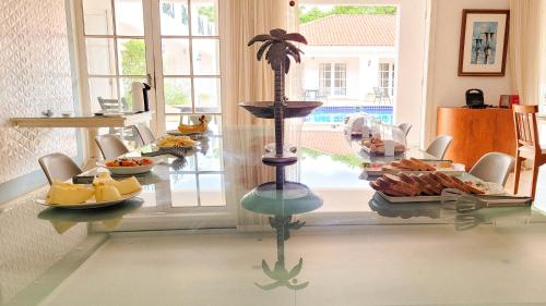 una stanza con un tavolo di vetro con del cibo sopra di Resort La Marina a Búzios