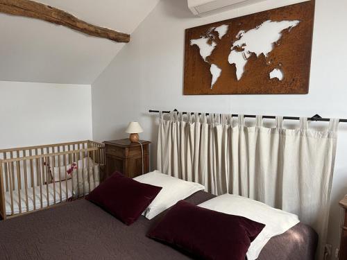 - une chambre avec un lit bébé et une carte du monde sur le mur dans l'établissement Domaine les Pierres, à Lacapelle-Ségalar