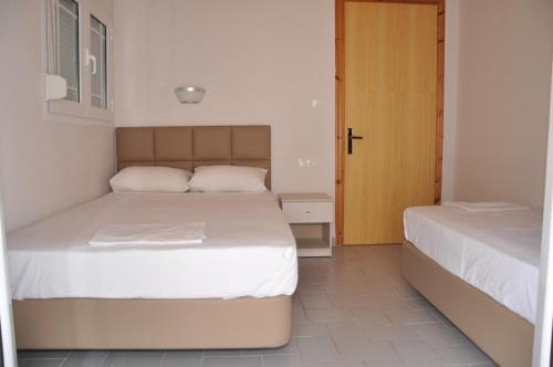 una camera con due letti e una porta di Villa Nikolas a Paralia Katerinis