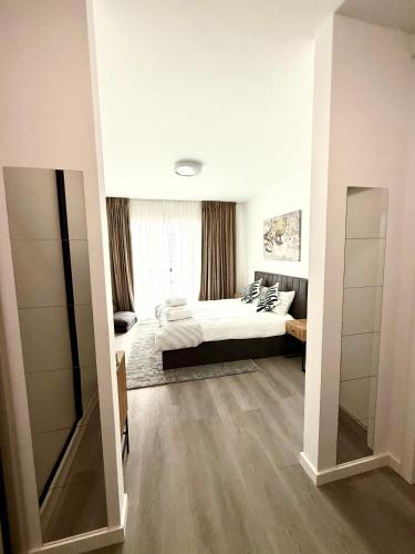 a bedroom with a bed and a large window at RULU Studio Plaza Mall in Bucharest