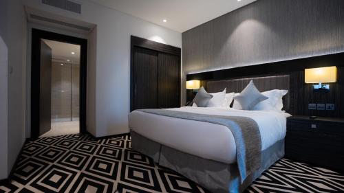 a hotel room with a large bed with white pillows at Mirada Blue Falestine - Serviced Apartments in Jeddah