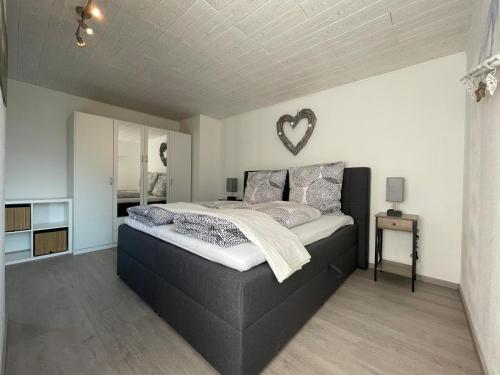 a bedroom with a large bed with a heart mirror on the wall at Moselgarten Bullay Zentral Grün Direkt an der Mosel in Bullay