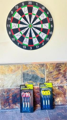 a dart board and some darts on a wall at Fela in Versace House in Gqeberha