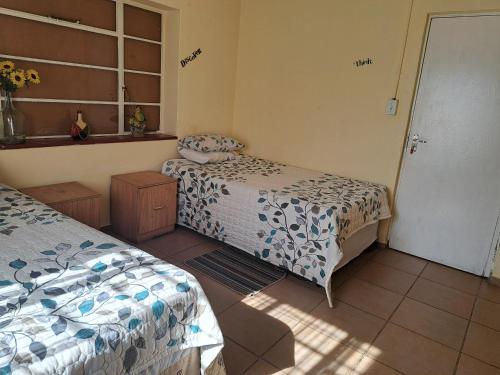 a bedroom with two beds and a window at KHAYA LANGA Guest House & Contractors Accommodation in Machadodorp