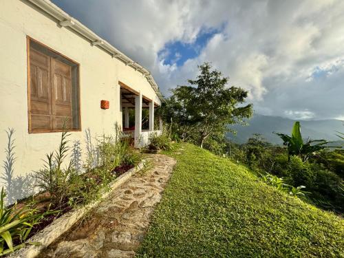 a house on the side of a grassy hill at Mountain Eco Lodge MUNDO ALTO in Minca