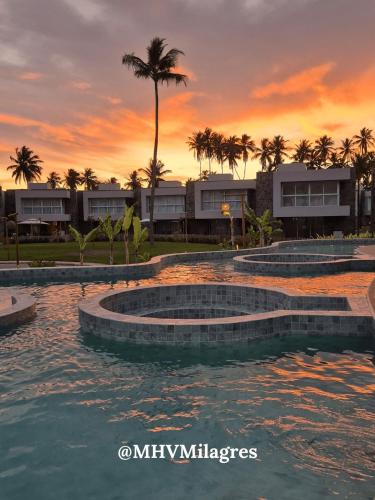 a group of pools with a sunset in the background at MHV Milagres - Naluum G04, Casa em condomínio beira mar de alto padrão, a poucos metros da Capela dos Milagres in Passo de Camarajibe