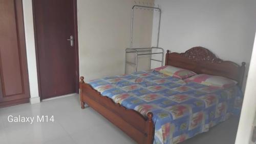 a bedroom with a bed with a blue comforter at Chanmira villa in Kelaniya