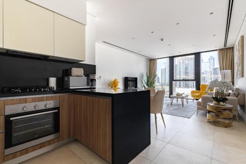 a kitchen with a counter and a living room at Simply Comfort Vacation Homes Rental Modern 1Br in the Heart of Dubai in Dubai