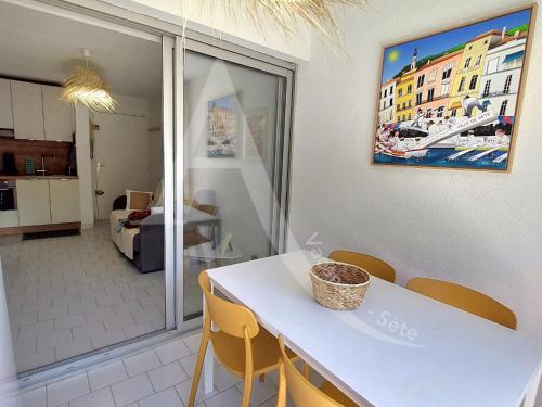 une cuisine et un salon avec une table et des chaises dans l'établissement Super rez de jardin, parking, internet, à Sète