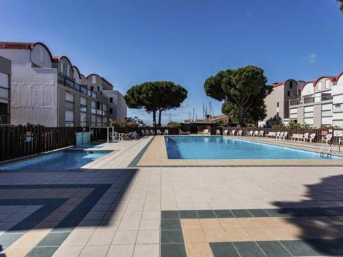 une piscine au milieu d'un immeuble dans l'établissement Studio Cabine Climatisé avec Terrasse et Piscine sur le Port de Gruissan, Proche Plage - 4 Couchages - FR-1-229-104, à Gruissan