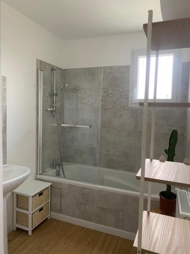a bathroom with a bath tub and a sink at Gîte la clé des champs in Bueil