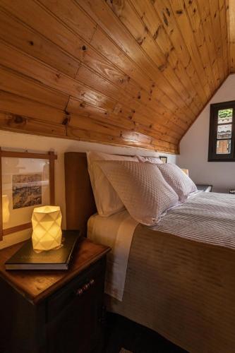 a bed in a room with a wooden ceiling at Cabana em Monte Verde com banheira e hidro in Camanducaia