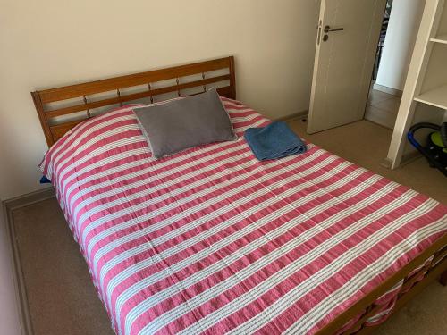 a bed with a striped comforter in a bedroom at Depto completo hasta 5 personas in Los Andes