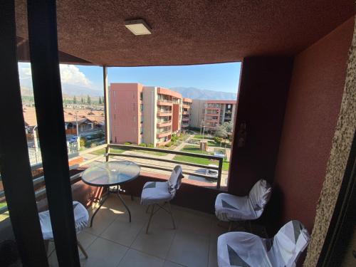 a balcony with a table and chairs and a large window at Depto completo hasta 5 personas in Los Andes