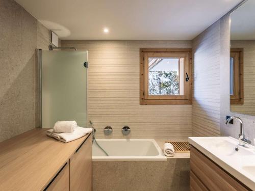 une salle de bain avec une baignoire et un lavabo dans l'établissement Superbe appartement skis aux pieds avec cheminée et parking à Méribel - FR-1-180-629, à Les Allues
