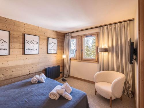 - une chambre avec un lit bleu et une chaise dans l'établissement Superbe appartement skis aux pieds avec cheminée et parking à Méribel - FR-1-180-629, à Les Allues