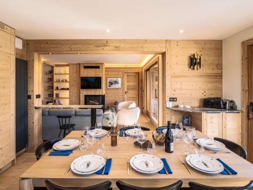 une salle à manger avec une table avec des assiettes et des verres à vin dans l'établissement Superbe appartement skis aux pieds avec cheminée et parking à Méribel - FR-1-180-629, à Les Allues