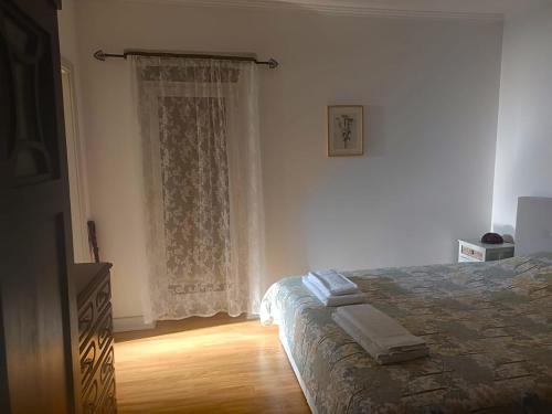 a bedroom with a bed and a dresser and a window at Casa da Celeste-AL in Areias