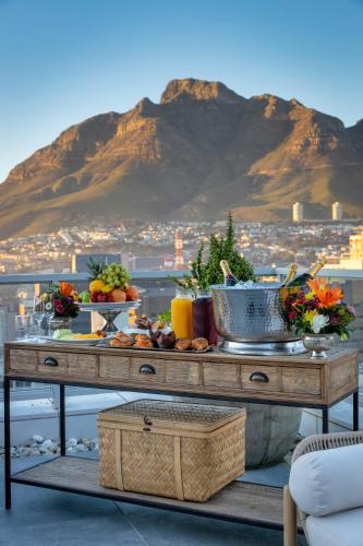 a table with food on it with a view of a mountain at Taj Cape Town in Cape Town
