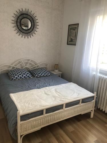 une chambre avec un lit avec un miroir au mur dans l'établissement Villa les peupliers, à Royan