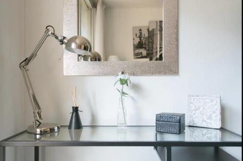 un bureau avec une lampe et une photo sur le mur dans l'établissement Appartement charmant proche Montparnasse, à Paris