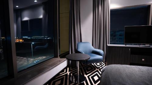 a room with a window with a chair and a table at Mirada Blue Falestine - Serviced Apartments in Jeddah