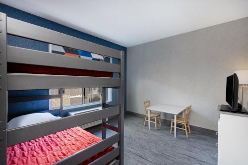 a bedroom with a bunk bed with a table and a desk at Holiday Inn Express and Suites Missoula by IHG in Missoula