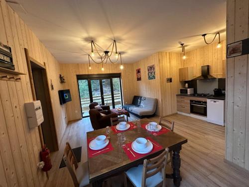 un soggiorno con tavolo da pranzo e una cucina di Grange de l'ancienne école avec Jacuzzi privé a Gérardmer