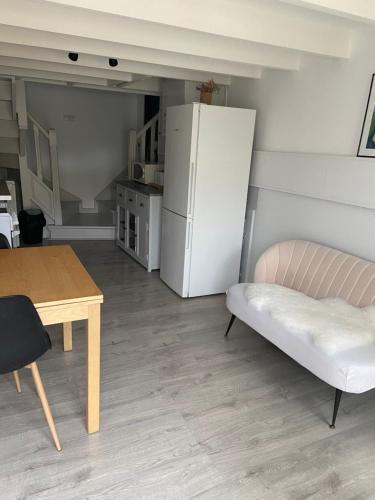un salon avec une table et un réfrigérateur dans l'établissement Studio 1 personne Vaucluse, à Carpentras