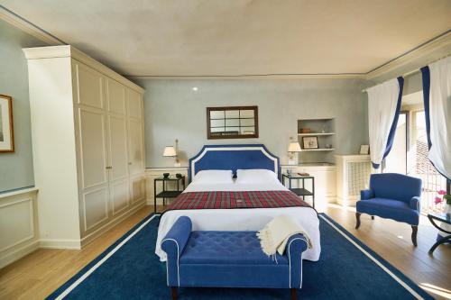 a bedroom with a blue bed and two blue chairs at Palazzo Niccolini al Duomo Residenza D'Epoca in Florence