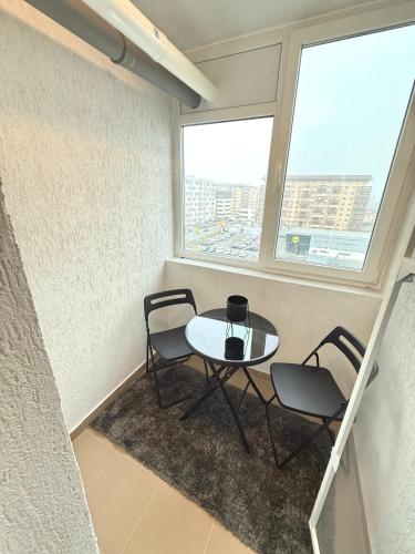 a table and chairs in a room with a window at RULU Studio Militari Residence Ballroom in Roşu