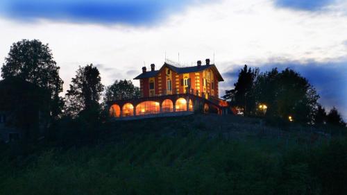 una grande casa in cima a una collina di notte di Agriturismo Villa Pallavicini a Serravalle Scrivia