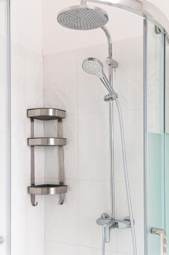 une douche avec pommeau de douche dans une salle de bain dans l'établissement Spacieux T2 proche la Défense, à Bezons