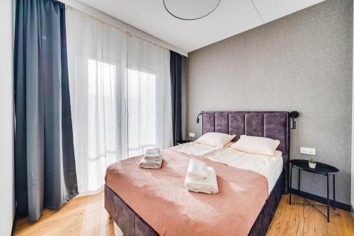 a bedroom with a large bed with two towels on it at ReVital Mechelinki by Homeprime Parking Free in Mechelinki